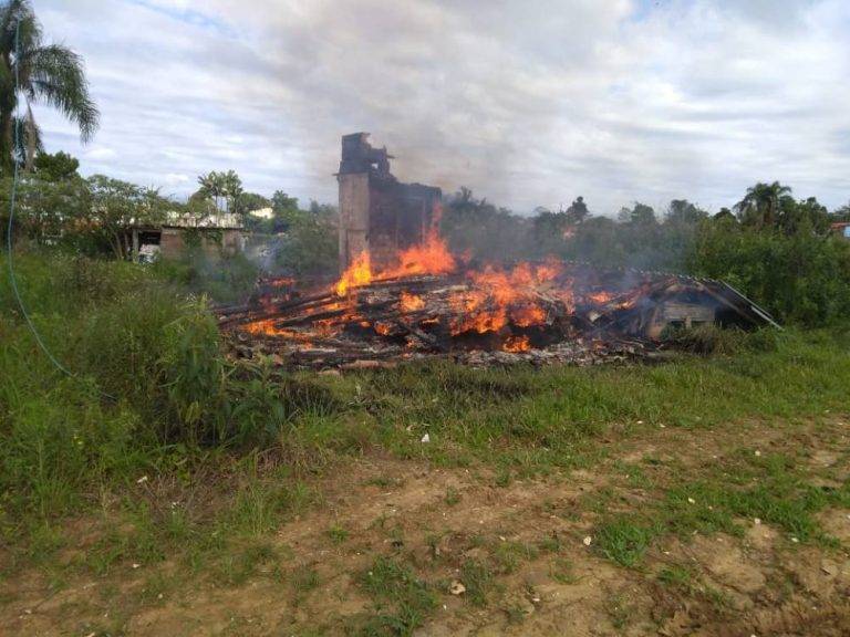 Casa abandonada de madeira pega fogo em área rural isolada