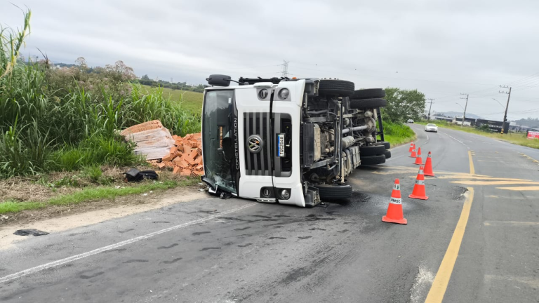 Caminhão carregado de tijolos tomba no meio da estrada em Tubarão