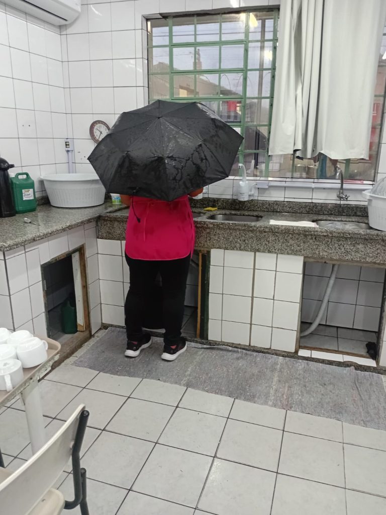 Merendeira usa guarda-chuva em refeitório de escola de Criciúma
